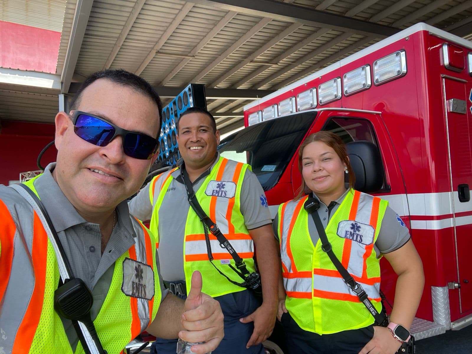 Arturo Villarreal and EMTS crew in high-visibility vests beside an ambulance