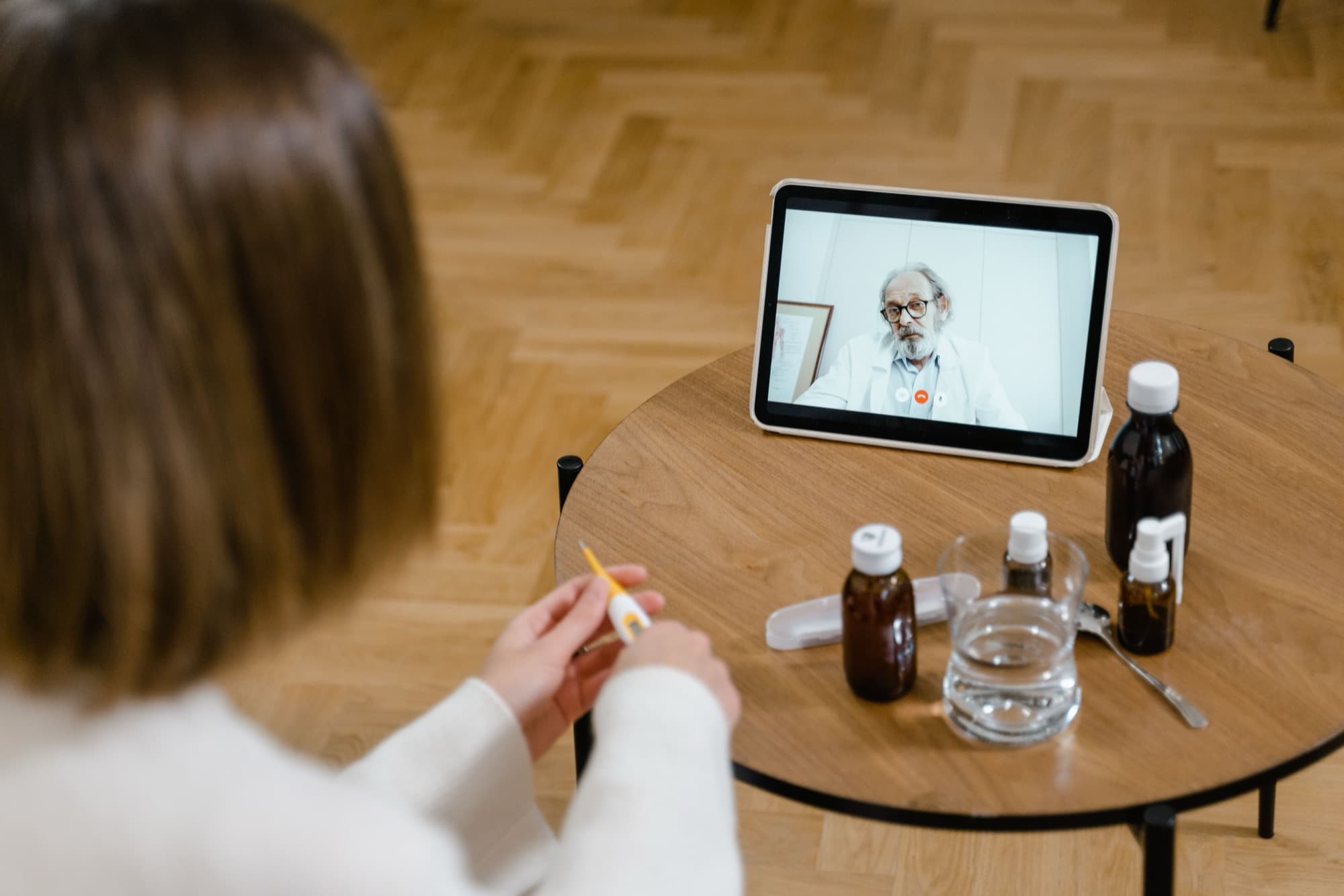 A patient at home consulting a doctor by video call on a tablet